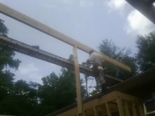 Carpenter setting a ridge beam over a new addition frame — Ice Dam Removal by Roofing Brothers in Pineola