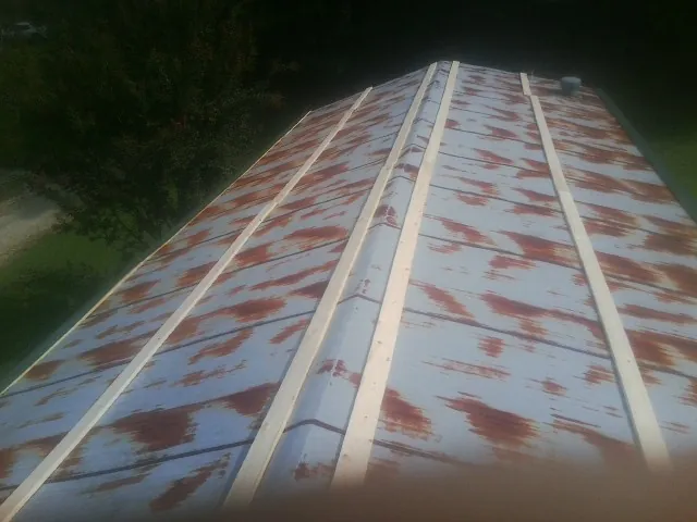 Rusted metal roof panels with new wood purlins before replacement — Storm Damage Roof Repair in Pineola by Roofing Brothers