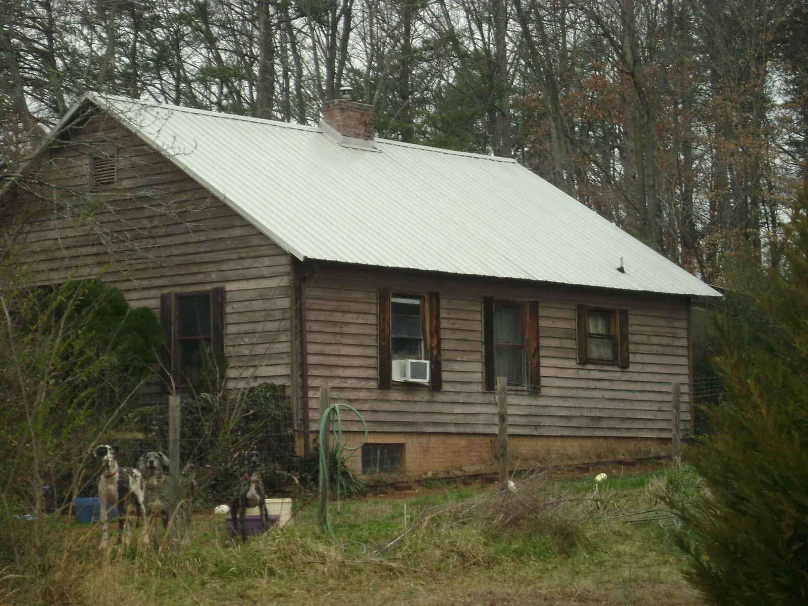 White metal roof on an old wood sided farmhouse, from a Metal Roof Installation job in Pineola